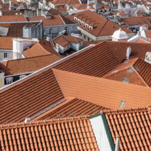 An aerial shot of rooftops of city buildings with red shingles